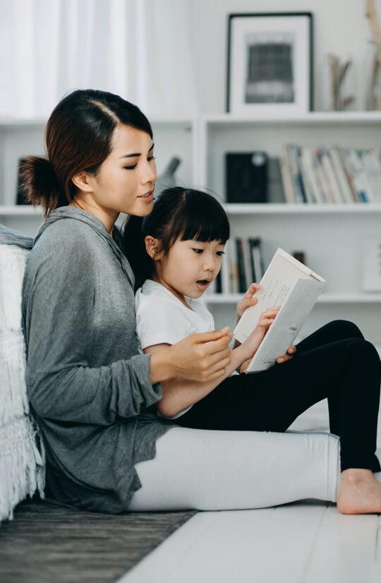 Mother helping daughter learn to read